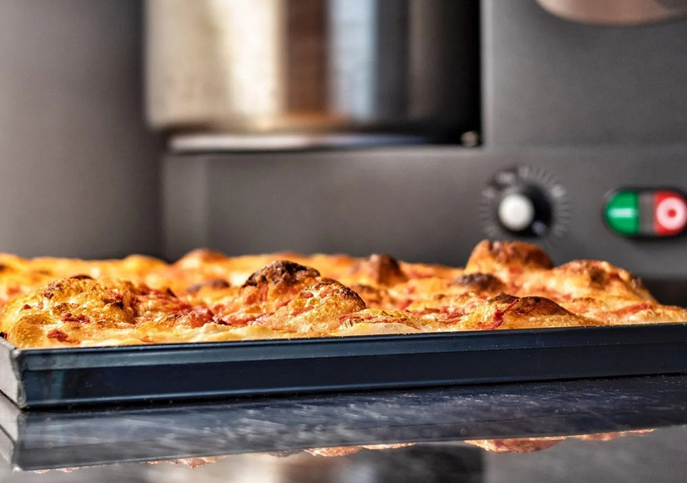 J'ai acheté une plaque à pizza en fonte bleue. Comment se comporte-t-elle lors de la première utilisation ?